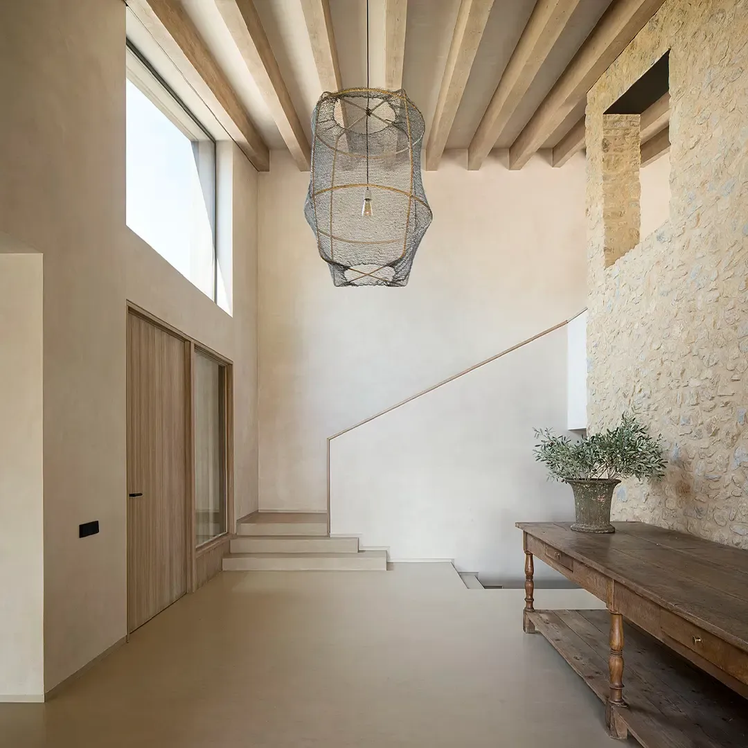 A double-height entrance hall with a seamless Microcemento® floor
