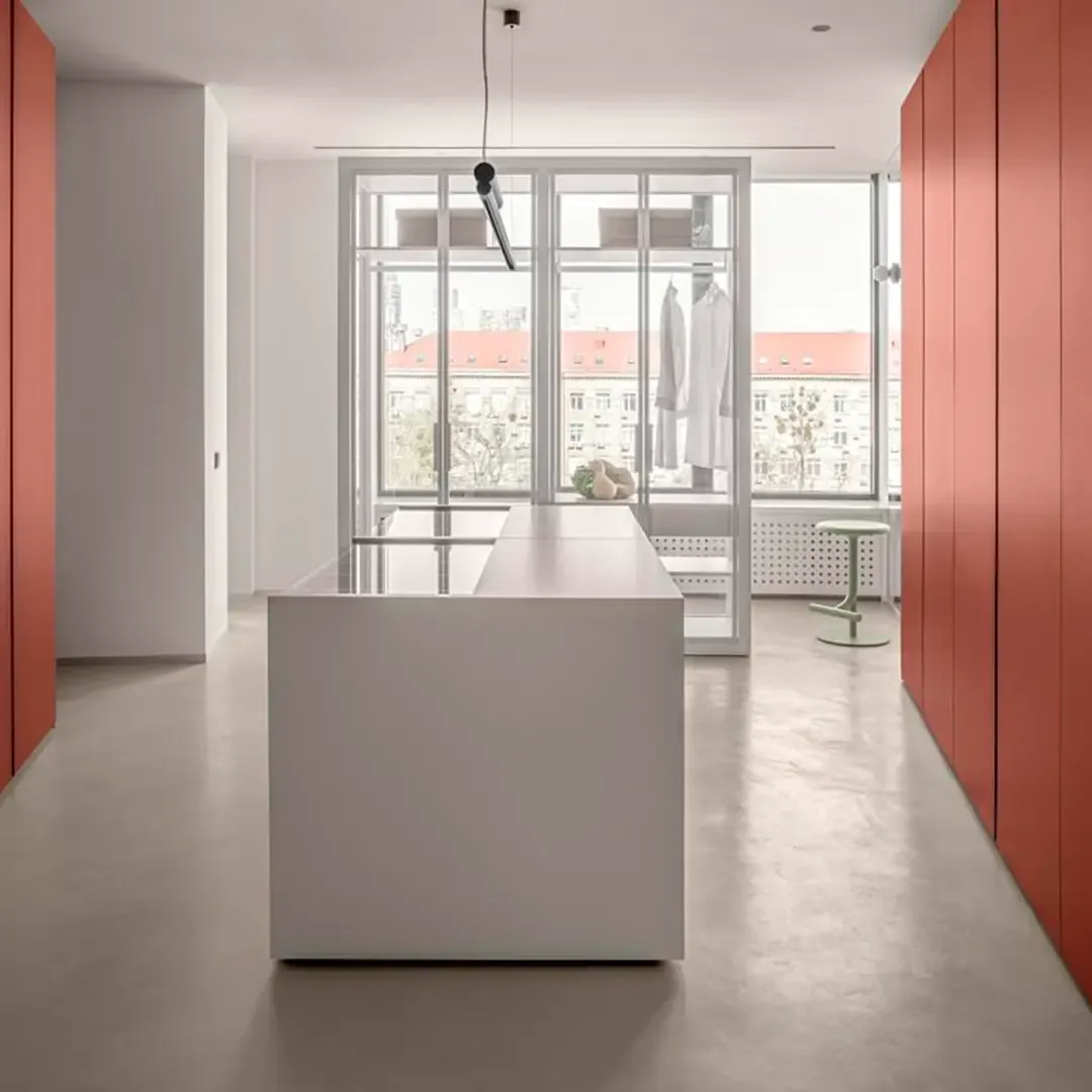 A kitchen with an island and a seamless Microcemento® floor